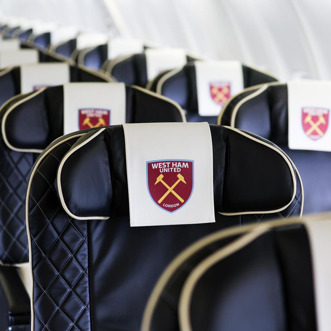 Plane seats with West Ham United headcovers